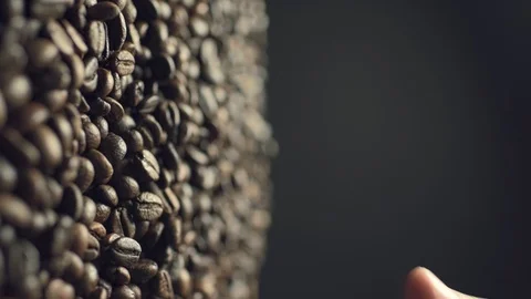 Closeup of coffee beans scatter out of male's hand in slow motion Stock Footage 125143389