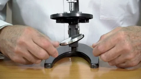 Closeup of college professor adjusting the mirror of microscope in the classroom Stock Footage 72000504