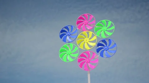 Closeup colorful plastic wind mill spin in wind on cloudy sky Stock Footage 32780542