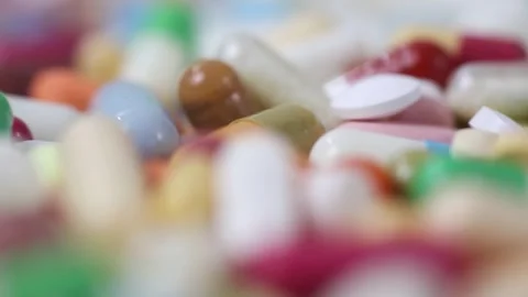 Closeup of colourful medication rotating with shallow depth of field Stock Footage 286218842