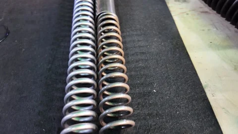 Closeup Comparison of New and Used Springs on Black Surface Stock Footage 324038977