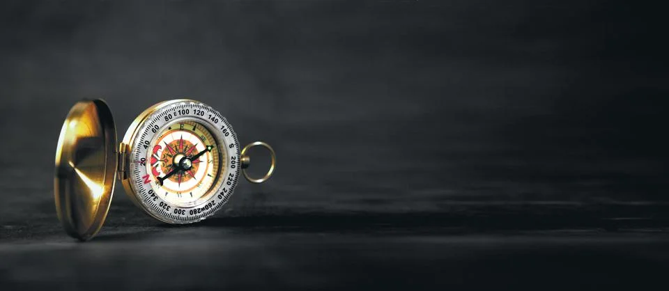 A closeup of a compass on a black background Stock Photos