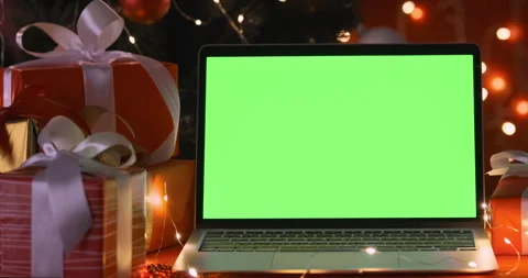 Closeup, computer green screen with red Christmas present. laptop with chroma Stock Footage 257200198