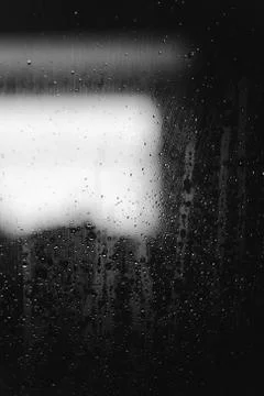 Closeup of condensation patterns on glass window, water droplets with light Stock-Fotos