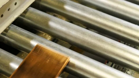 Closeup conductor made of copper plate moves along conveyor and rotates rollers Stock Footage 92016322