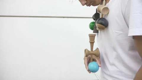 Closeup of confident boy playing with kendama toy and practicing balance bord Stock Footage 81429497
