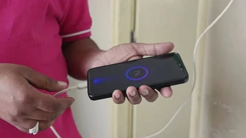 A closeup of connecting the charging cable to the phone Stock Footage 231545081