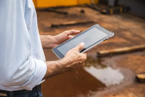 Closeup construction engineer male worker hand holding tablet computer work.. Stock Photos
