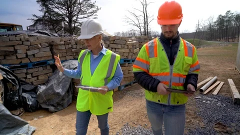 Closeup of construction job foreman walking and talking with project engineer on Stock Footage 127122950