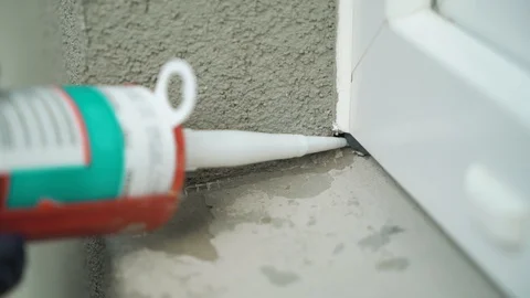 Closeup construction work applying silicone sealing with caulking gun for Stock Footage 91988140