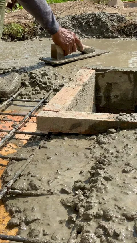 Closeup of a construction workers rubber boot stepping into wet concrete Видео 334533723