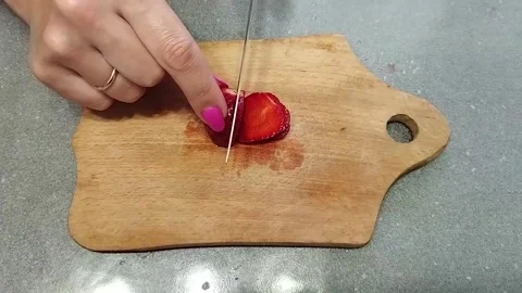Closeup cook cuts strawberries on a cutting board. Stock Footage 161795292