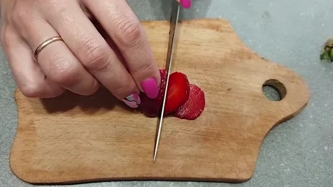 Closeup cook cuts strawberries on a cutting board. Stock Footage 161795322