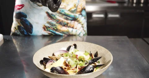 Closeup cook hands adding pepper to carbonara pasta with mussels and vegetables Stock Footage 134316287