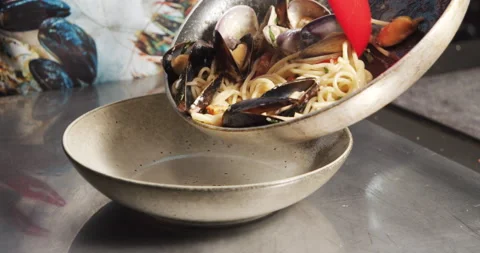 Closeup cook hands serving delicious carbonara pasta with mussels and vegetables Stock Footage 134291368