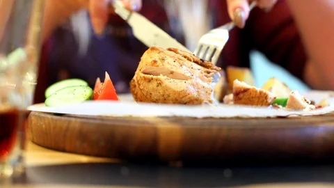 Closeup of cooked tasty meat dish with vegetables on wooden board. Female hand t 動画素材 117675360