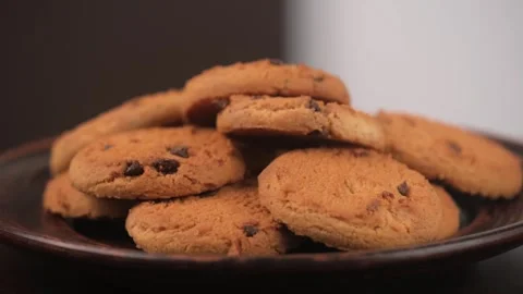Closeup cookie on clay plate rotates on a brown background. delicious dessert. Stock Footage 247004556