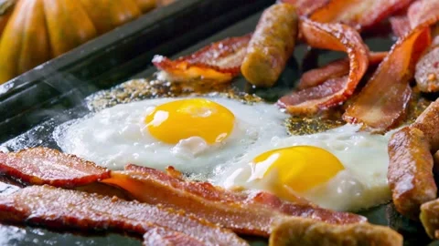 Closeup of Cooking Bacon and Egg in frying Pan. Fast and easy breakfast concept. 스톡 동영상 334643375