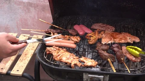 Closeup cooking chicken pieces, anticuchos, hot dog and chorizo on the grill 库存影片 143376527