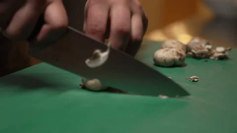 Closeup of a cook's hands slicing fresh champignons with a knife Video stock 333578867