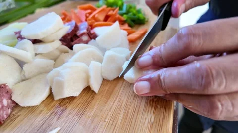 Closeup of a cook's hands using a kitchen knife to slice Stock Footage 329343245