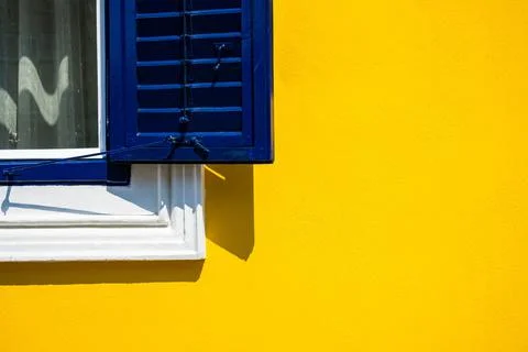 Closeup of a corner of window on a yellow building- can be used as background Fotos de archivo
