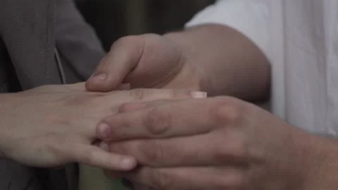 Closeup of a couple getting engaged, a male putting a ring on a female's finger Stock Footage