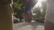 Closeup Of Couple Holding Hands, Walking Down The Middle Of Street (Slow Motion) Stock Footage