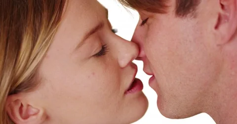 Closeup of couple sharing intimate moment, kissing tenderly on white background Vidéo 77232961