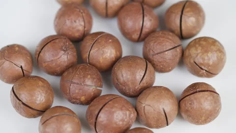 Closeup of cracked macadamia nuts on white background. Artistic macro compositio Stock Footage 331792931