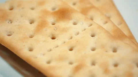 Closeup of a cracker with salt. snack on a white plate. tea biscuits Video stock 99598122