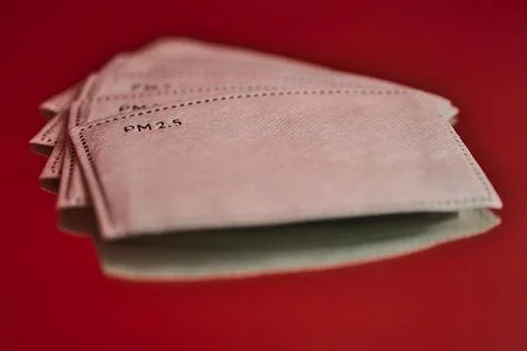 Closeup creative view of white PM 2.5 filters on red reflective background Stock Photos