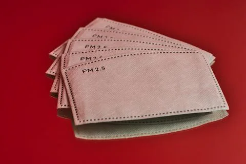 Closeup creative view of white PM 2.5 filters on red reflective background Stock Photos