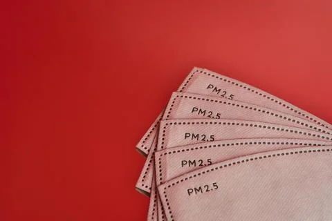 Closeup creative view of white PM 2.5 filters on red reflective background Stock Photos