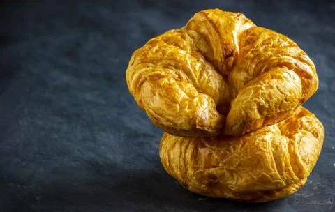 Closeup croissant on table in dark background. Stock Photos