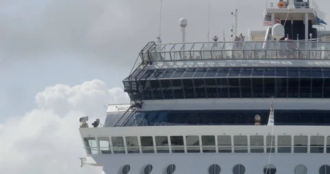 Closeup of a cruise ship upper deck docked at a tropical port on a sunny cloudy Stock Footage 125112243