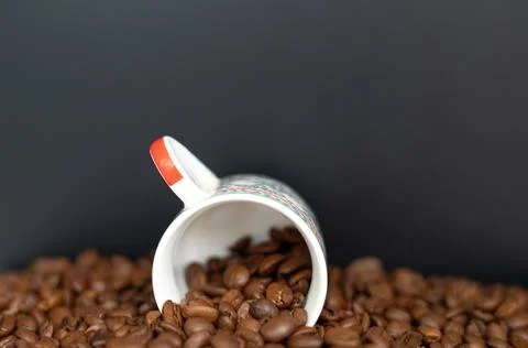 Closeup of a cup of coffee with roasted dark brown coffee beans Stock Photos