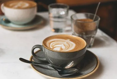 Closeup of a cup of latte with an art pattern on a table in a cafe Fotos de archivo