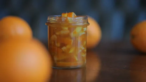 Closeup. Cup Of Orange Jam And Oranges On The Wooden Table. HD Video Footage Video stock 100381330