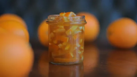 Closeup. Cup Of Orange Jam And Oranges On The Wooden Table. HD Video Footage Video stock 100381430