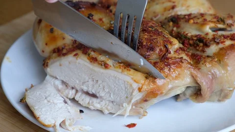 Closeup of a cut piece of fried chicken on a wooden background Stock Footage 129323083