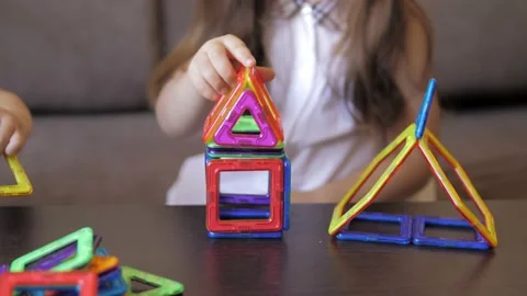 Closeup of cute 5 years old girl is sitting at the table on a sofa and playing a Stock Footage 227021482