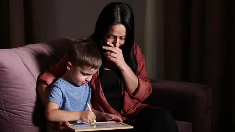 Closeup cute son and young mother drawing with colored pencils and markers Stock Footage 251629500