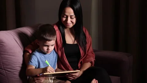 Closeup cute son and young mother drawing with colored pencils and markers Stock Footage 251629731