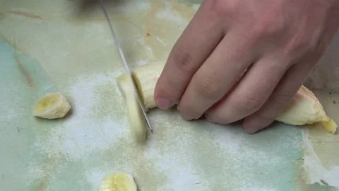 Closeup cutting a banana on a table Stock Footage 141034998