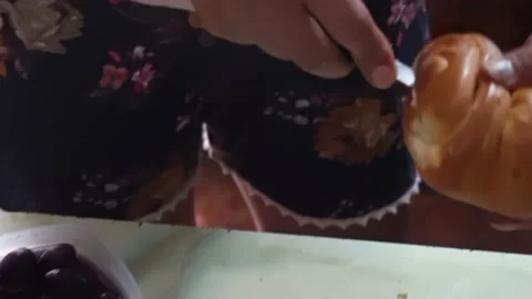 Closeup cutting a bread with a knife with her hands preparing breakfast Stockbeeldmateriaal 147875849