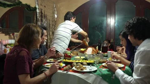 Closeup cutting a cooked turkey with an electric knife and tongs at a family Stock Footage 171996164