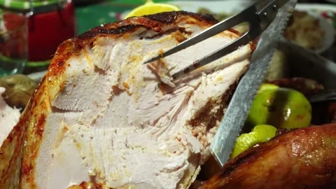 Closeup cutting a cooked turkey with an electric knife and tongs at a christmas Stock Footage 171996199