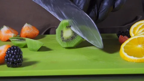 Closeup cutting fruit for a fruit salad in slow motion Stock Footage 127855090