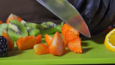 Closeup cutting fruit for a fruit salad in slow motion Stock Footage 127855201